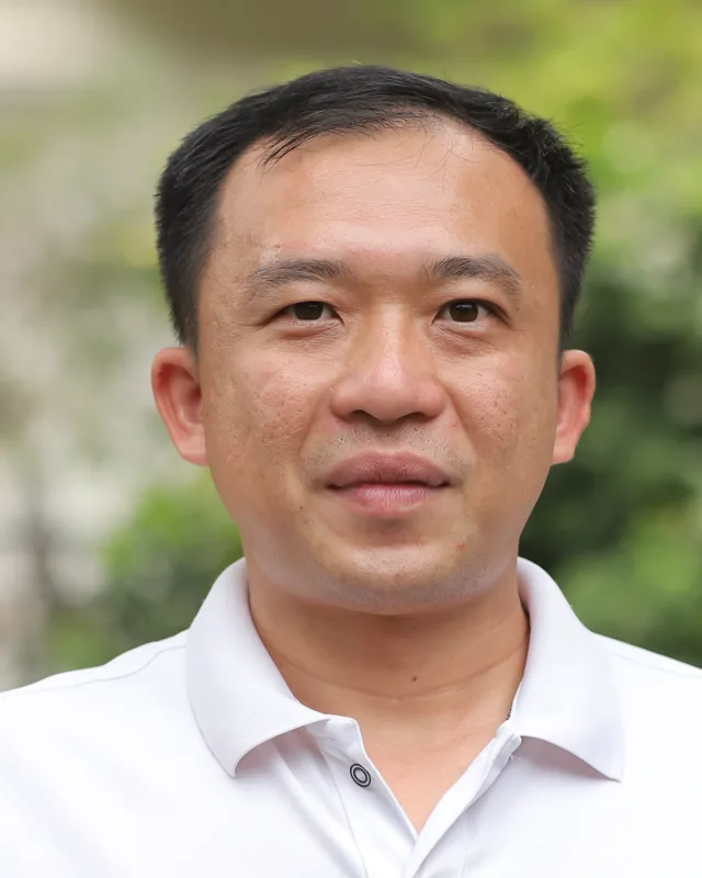 Chân dung Giám Đốc chuyên môn Phan Hồng Sơn, chụp ngoài trời, mặc áo polo trắng